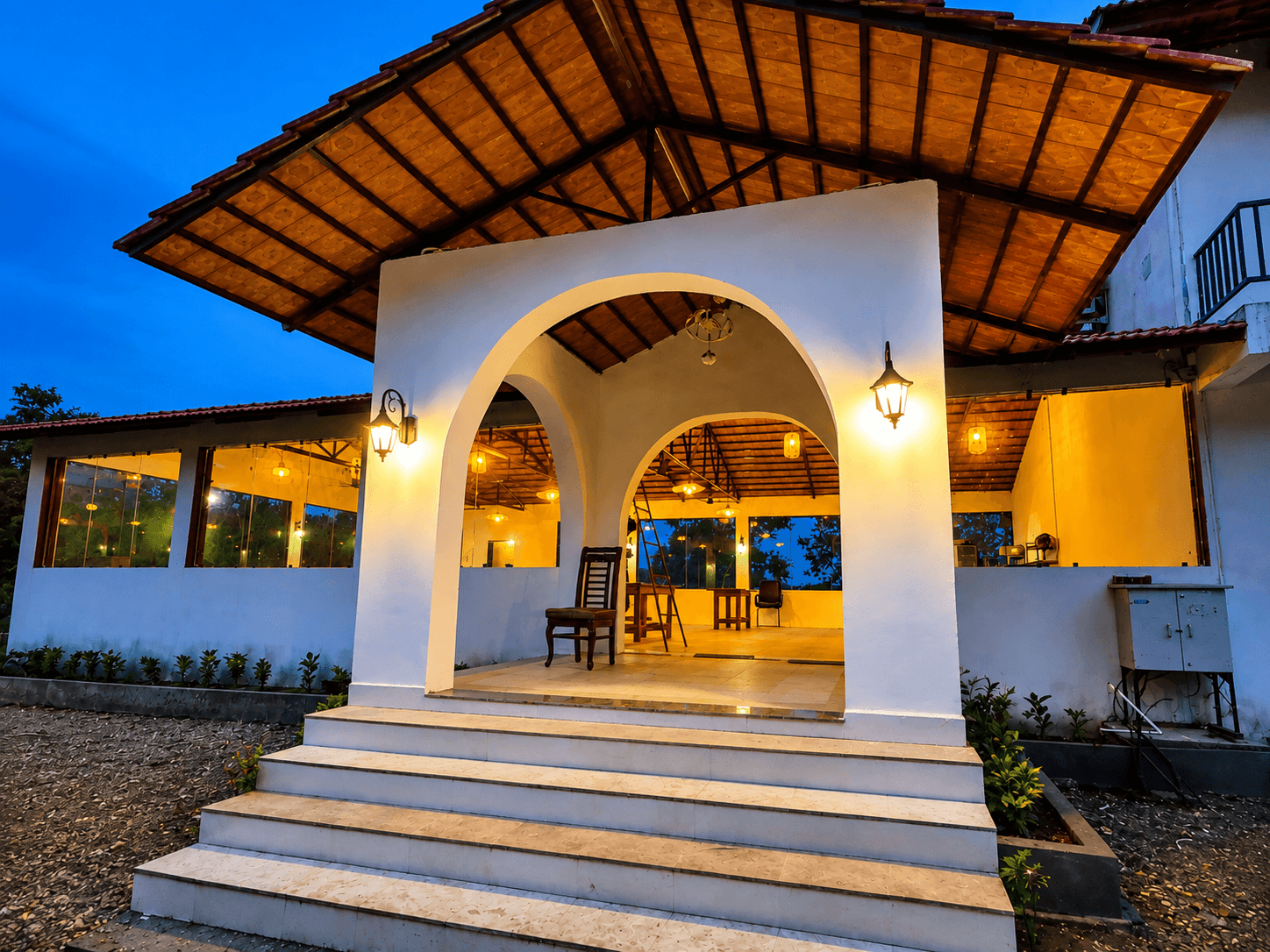 Warm-lit entrance pavilion at Avora Wilderness Resort in the evening